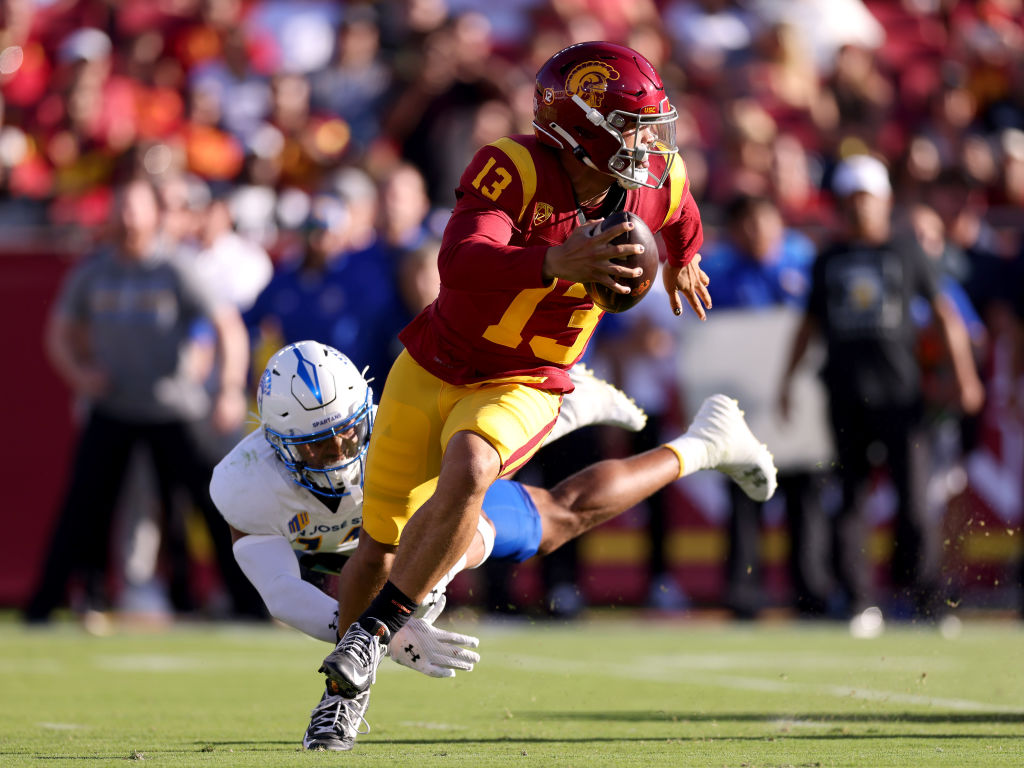 LOS ANGELES, CALIFORNIA - AUGUST 26: Caleb Williams #13 of the USC Trojans avoids the tackle against Elijah Wood #14 of the San Jose State Spartans during the second quarter at United Airlines Field at the Los Angeles Memorial Coliseum on August 26, 2023 in Los Angeles, California.